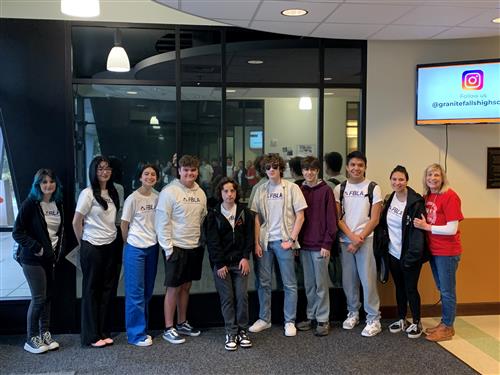  nine students and a teacher face the camera and smile